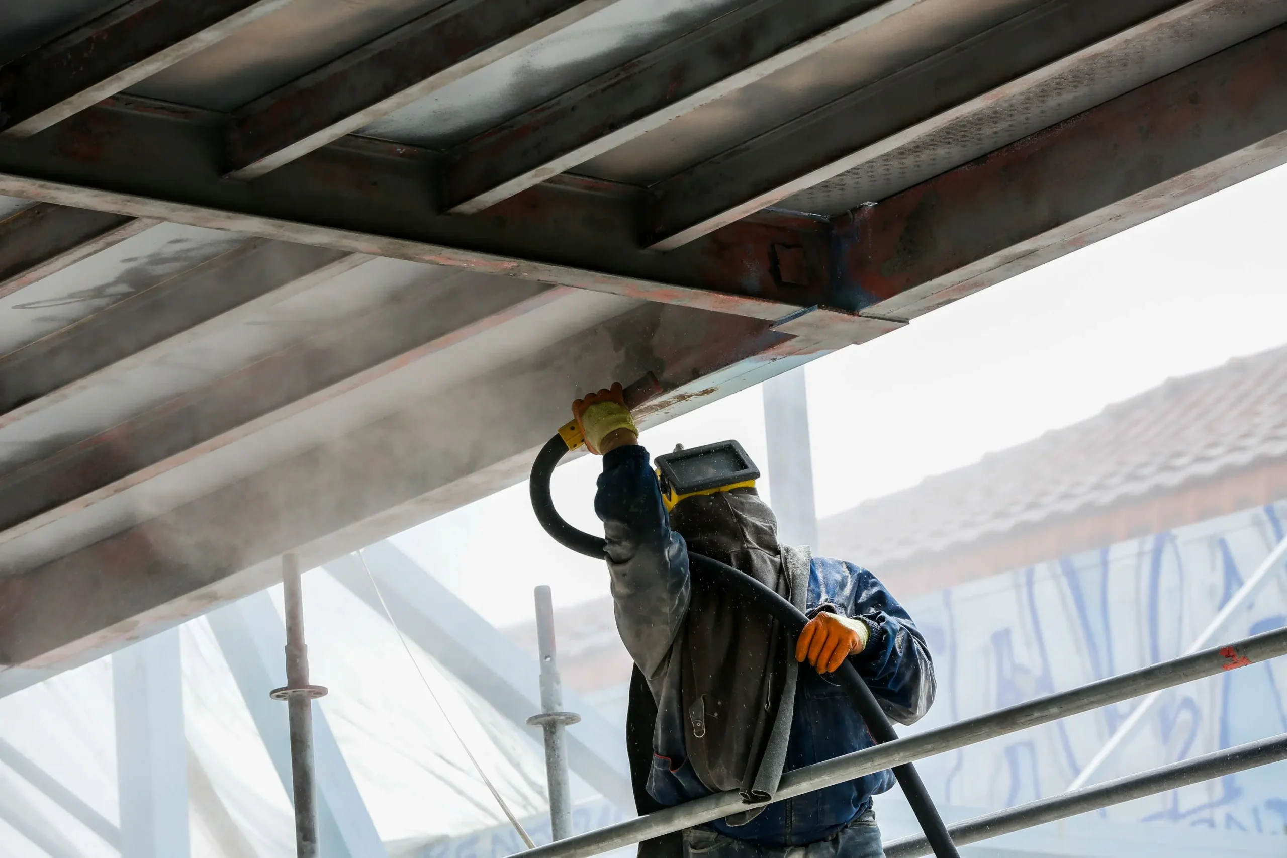 Technician comparing soda, glass bead, and garnet blasting media on industrial equipment in Alberta