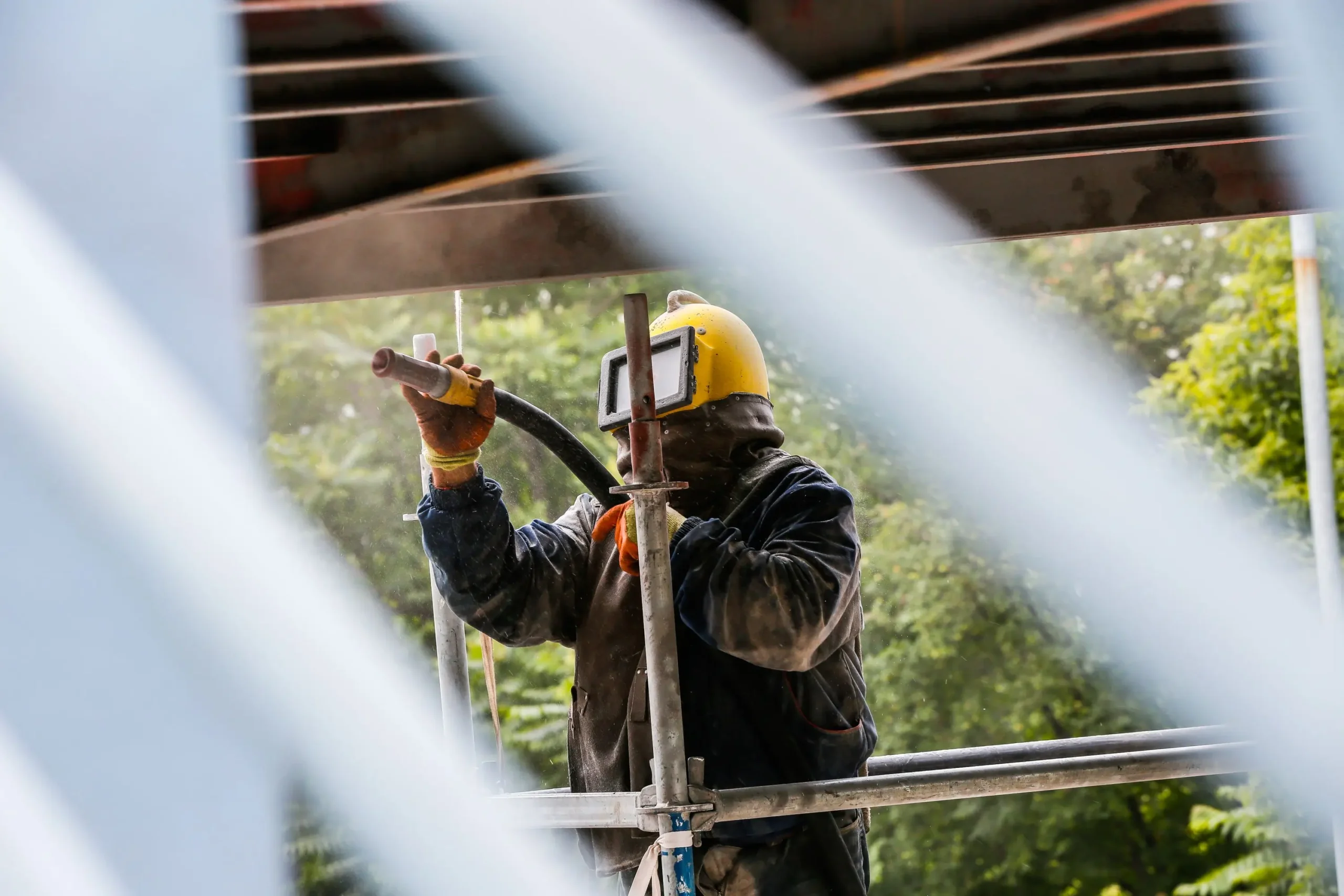 Mobile abrasive blasting service in Alberta preparing heavy equipment surfaces